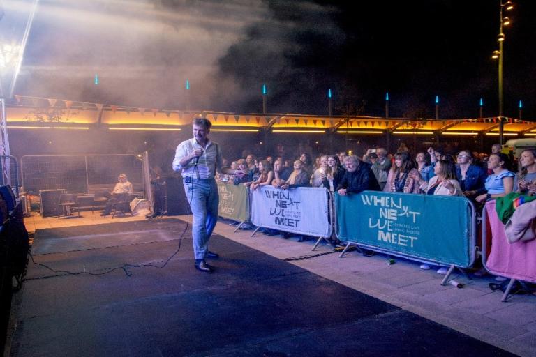 image of performer at outdoor event with crowd in background